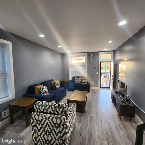 a living room with furniture and wooden floor
