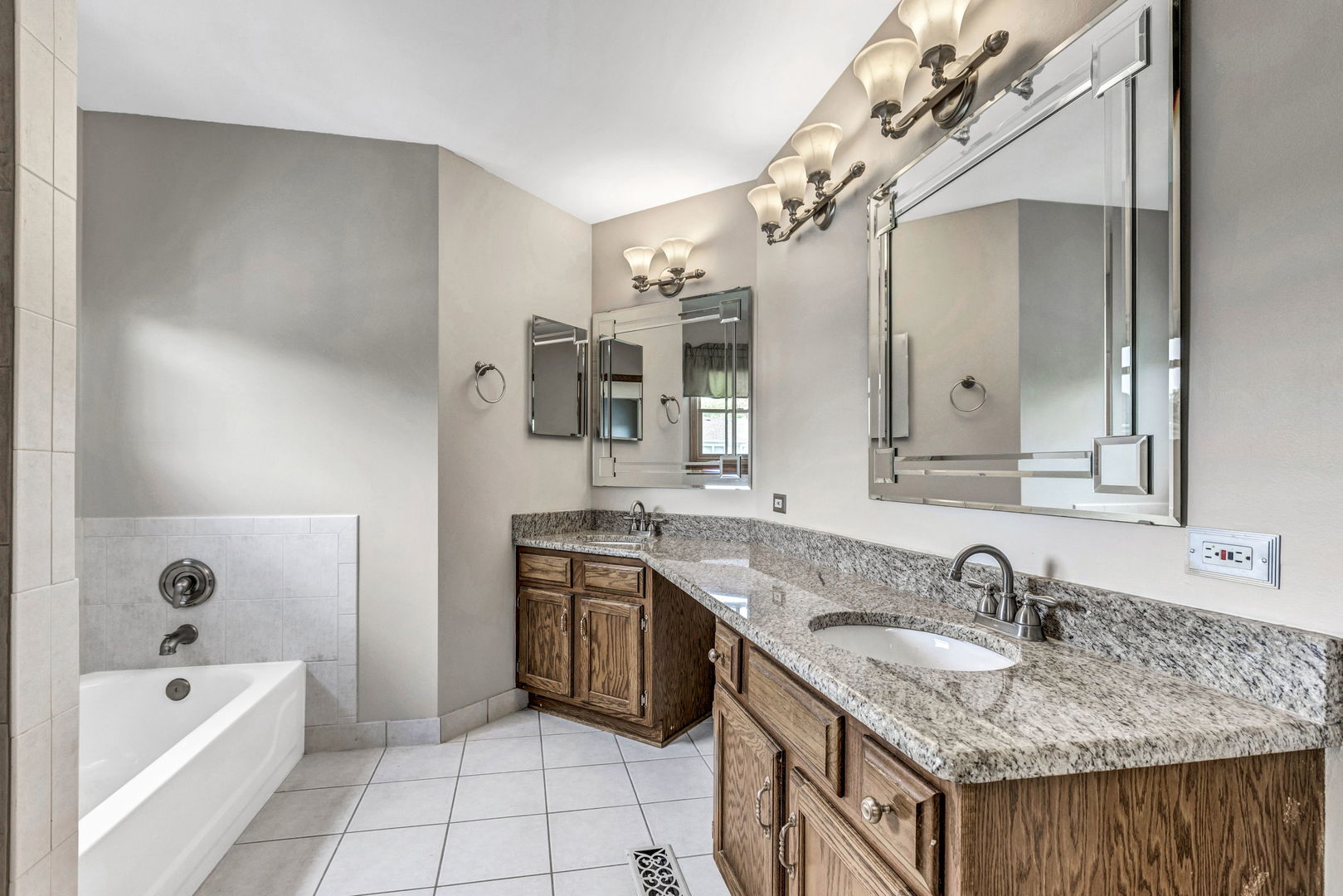 1726 Biesterfield Road Elk Grove Village, IL 60007 - Photo 14 of 25 a bathroom with a granite countertop sink a mirror and a bathtub