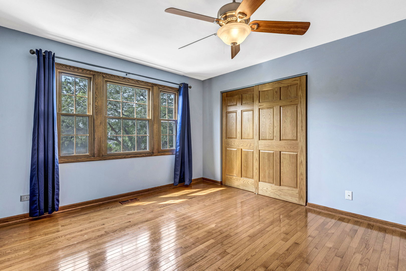 1726 Biesterfield Road Elk Grove Village, IL 60007 - Photo 17 of 25 an empty room with wooden floor chandelier fan and windows