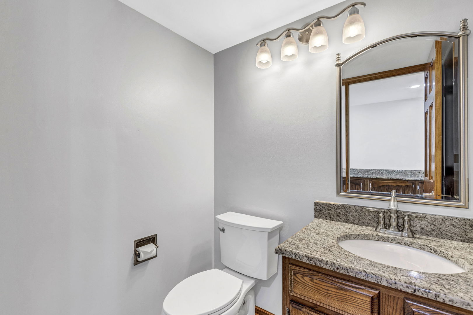 1726 Biesterfield Road Elk Grove Village, IL 60007 - Photo 19 of 25 a bathroom with a granite countertop toilet sink and mirror