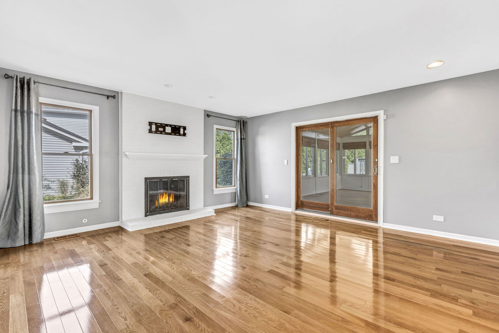 1726 Biesterfield Road Elk Grove Village, IL 60007 - Photo 3 of 25 a view of empty room with wooden floor and fireplace