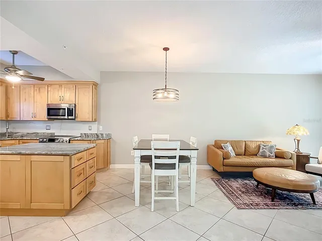 a kitchen with stainless steel appliances kitchen island granite countertop a stove a sink and a refrigerator