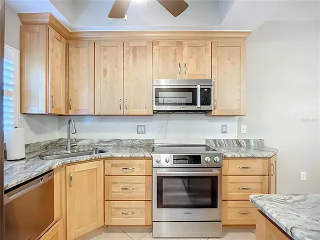 a kitchen with granite countertop a stove top oven microwave and cabinets