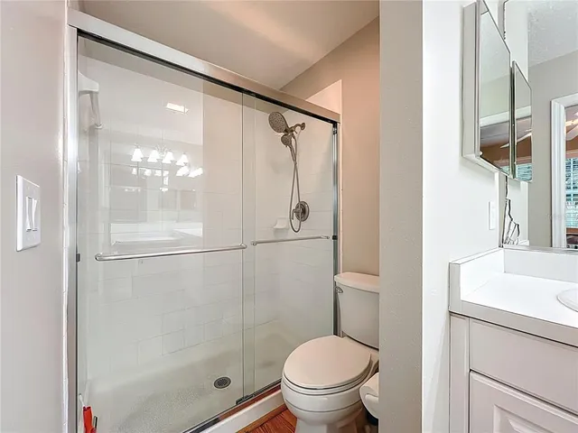 a bathroom with a granite countertop sink toilet and shower