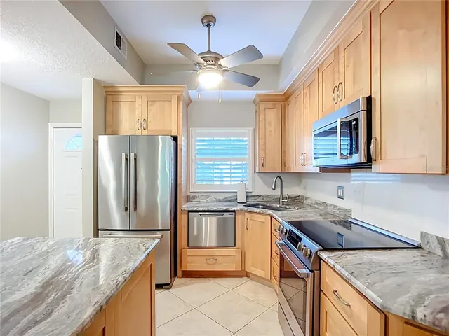 a kitchen with stainless steel appliances granite countertop a sink a stove and a refrigerator