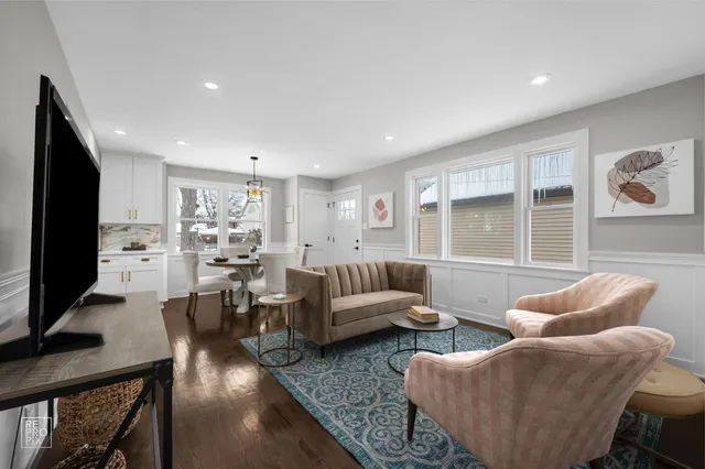 a living room with furniture wooden floor and a flat screen tv