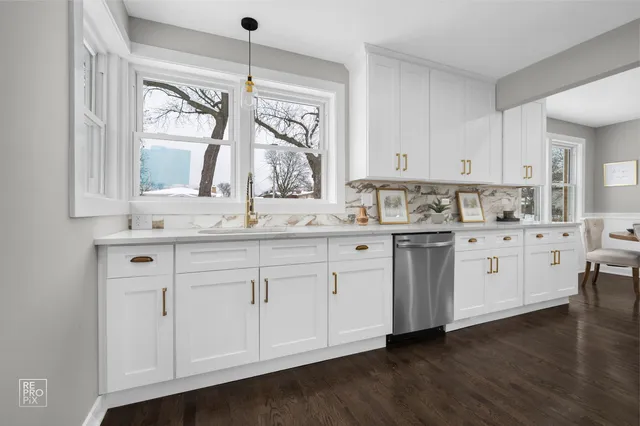 a kitchen with stainless steel appliances granite countertop a sink a stove and cabinets