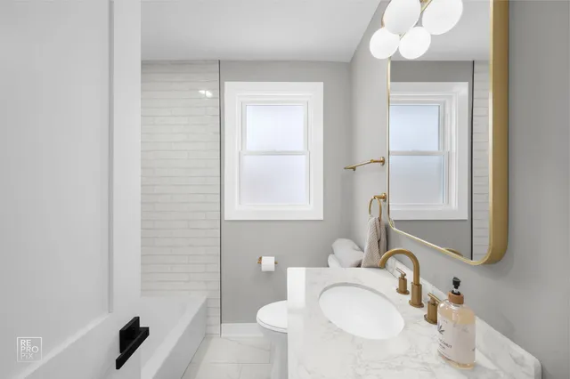 a bathroom with a sink vanity tub and a mirror