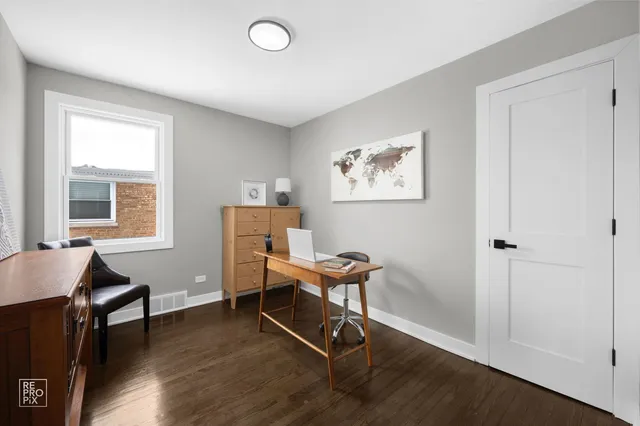 a view of a workspace with furniture and a window