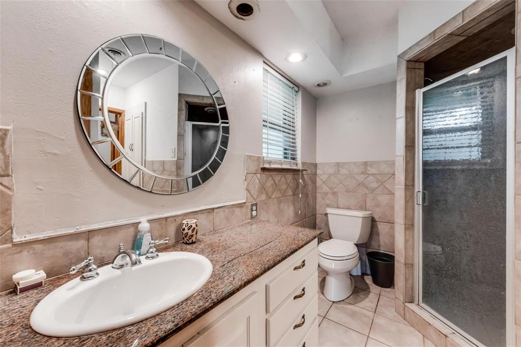 821 North Hampton Road Dallas, TX 75208 - Photo 9 of 11 a bathroom with a granite countertop toilet a sink and a mirror
