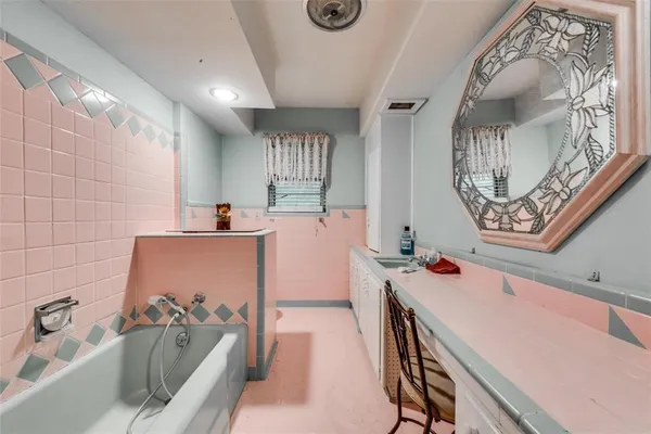 a bathroom with a tub sink and mirror