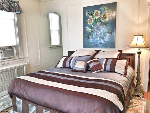 a bedroom with a bed and a painting on the wall