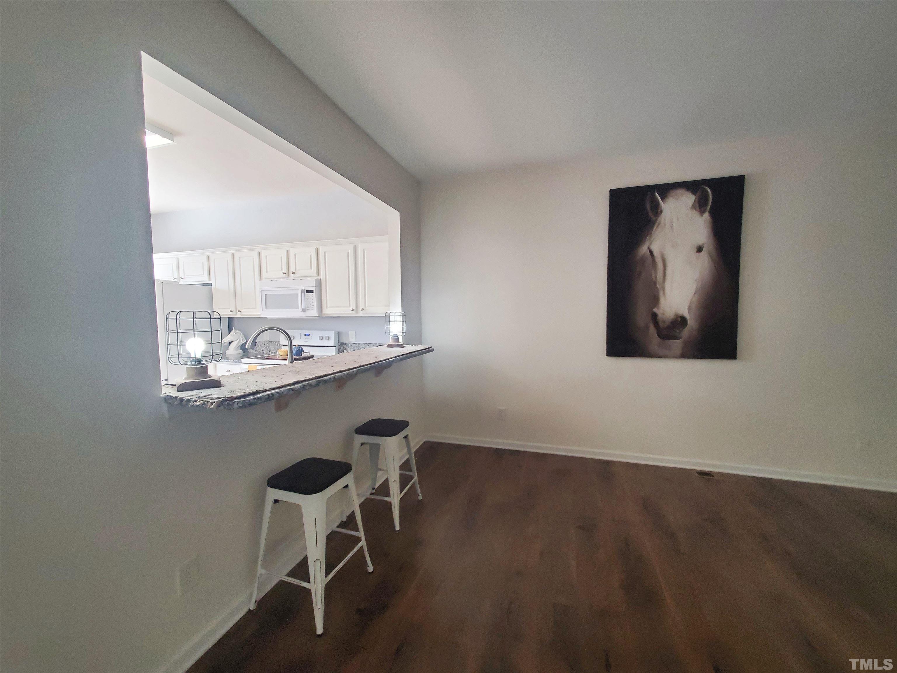 7236 Galon Glen Road Raleigh, NC 27613 - Photo 11 of 24 a room with a table chairs and wooden floor