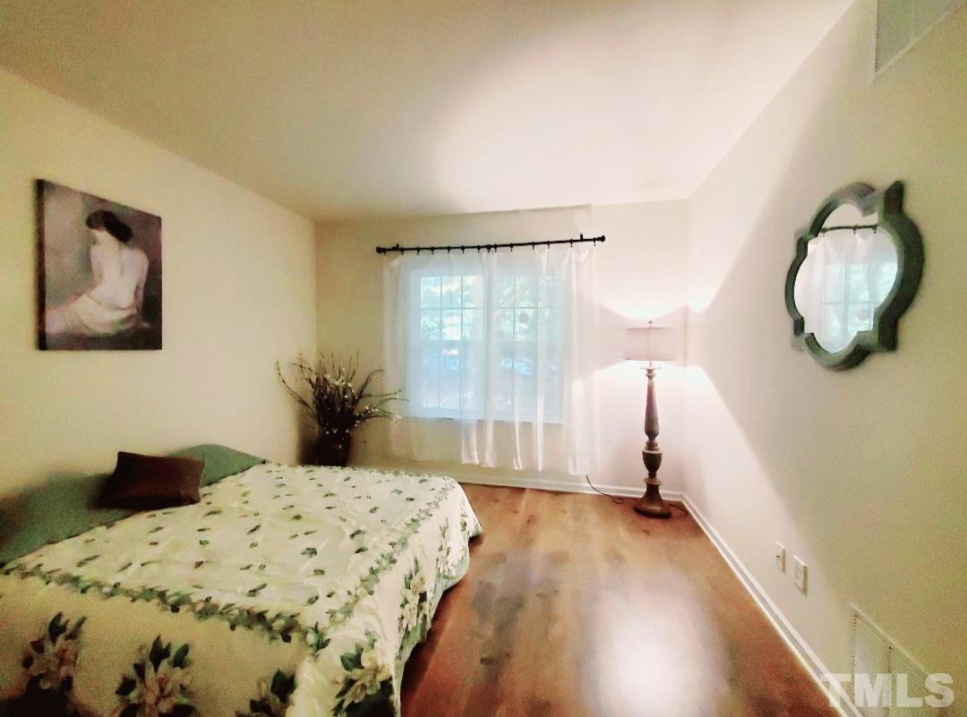 7236 Galon Glen Road Raleigh, NC 27613 - Photo 6 of 24 a bedroom with a large bed and a chandelier