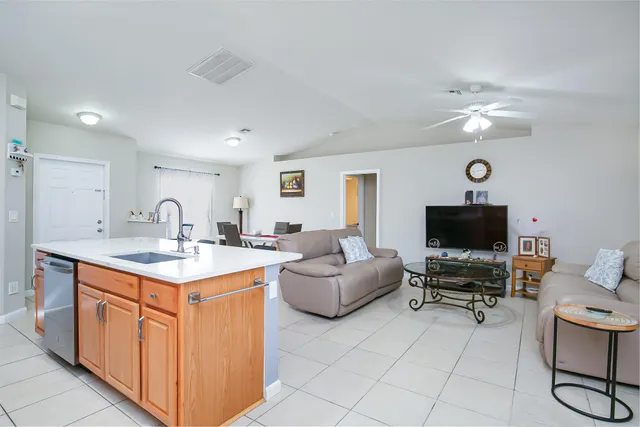 a living room with furniture a clock and a flat screen tv