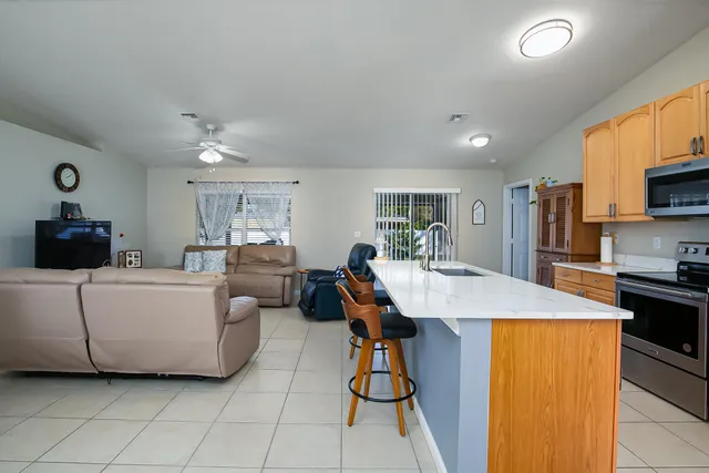 a living room with furniture and a dining table with kitchen view