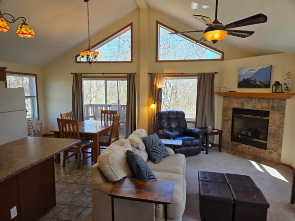 a living room with furniture a fireplace and a dining table with wooden floor