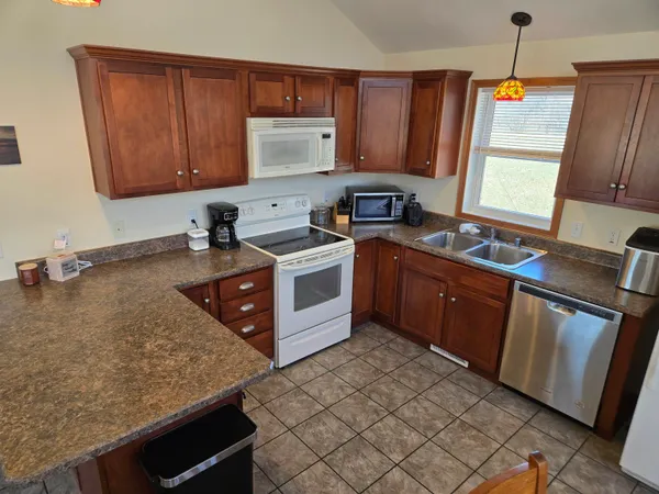 a kitchen with stainless steel appliances granite countertop a sink stove and microwave