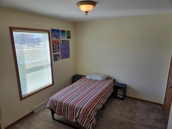 a bedroom with a bed and a window