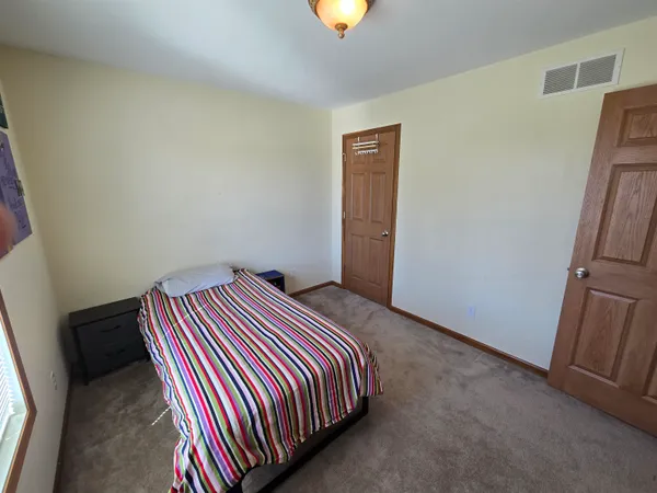 a bedroom with a bed and painting on the wall