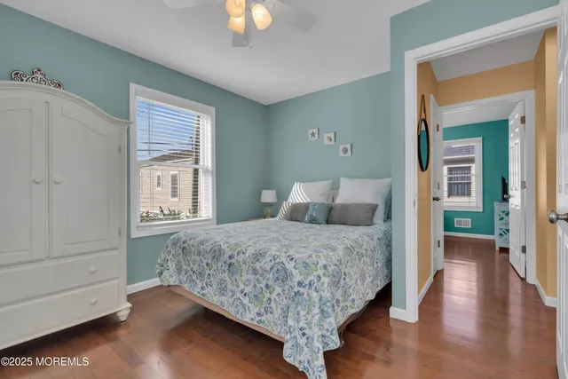 a bedroom with a large bed and wooden floor