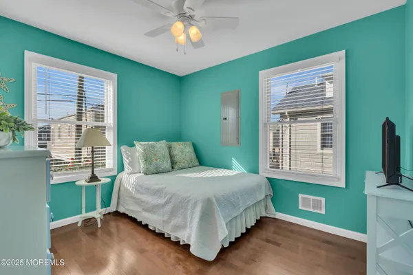 a bedroom with a bed and a flat tv screen on dresser