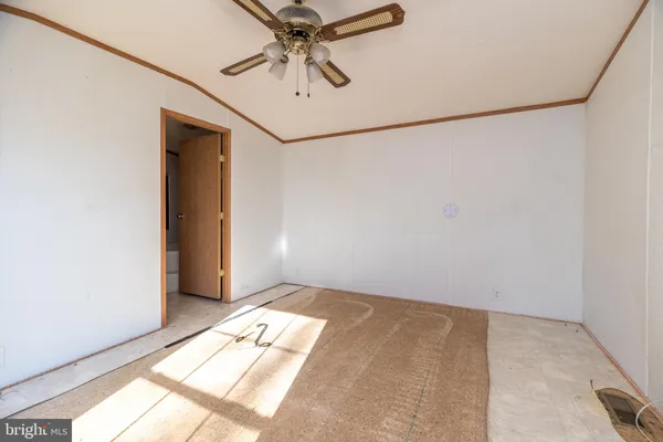 an empty room with windows and ceiling fan