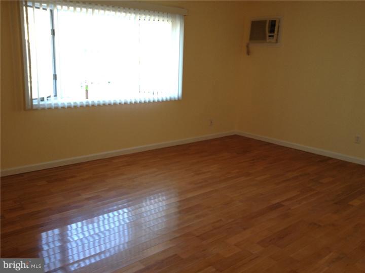 28 Comstock Road Edison, NJ 08817 - Photo 10 of 18 an empty room with wooden floor and windows