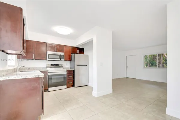 a kitchen with stainless steel appliances a stove top oven a sink a counter top space and cabinets