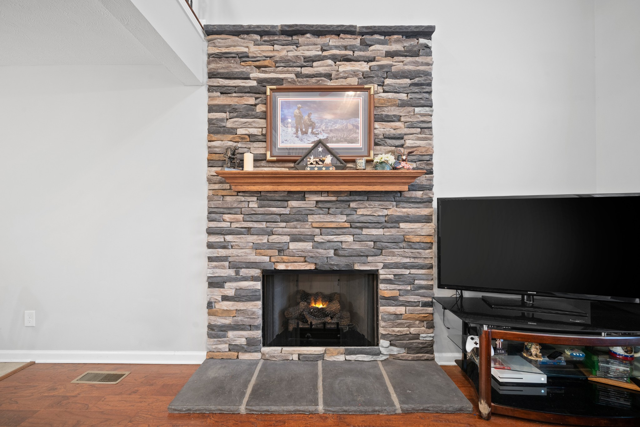 4218 Station Road Cunningham, TN 37052 - Photo 15 of 32 a living room with a fireplace and a flat screen tv