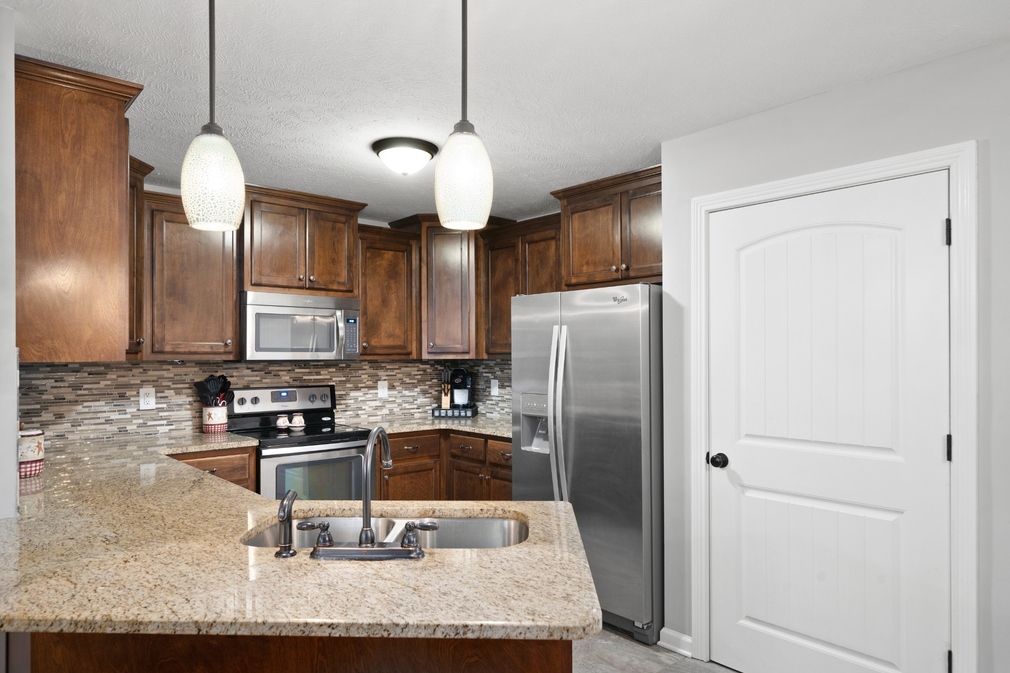 4218 Station Road Cunningham, TN 37052 - Photo 9 of 32 a kitchen with granite countertop a refrigerator a stove a sink and a cabinets