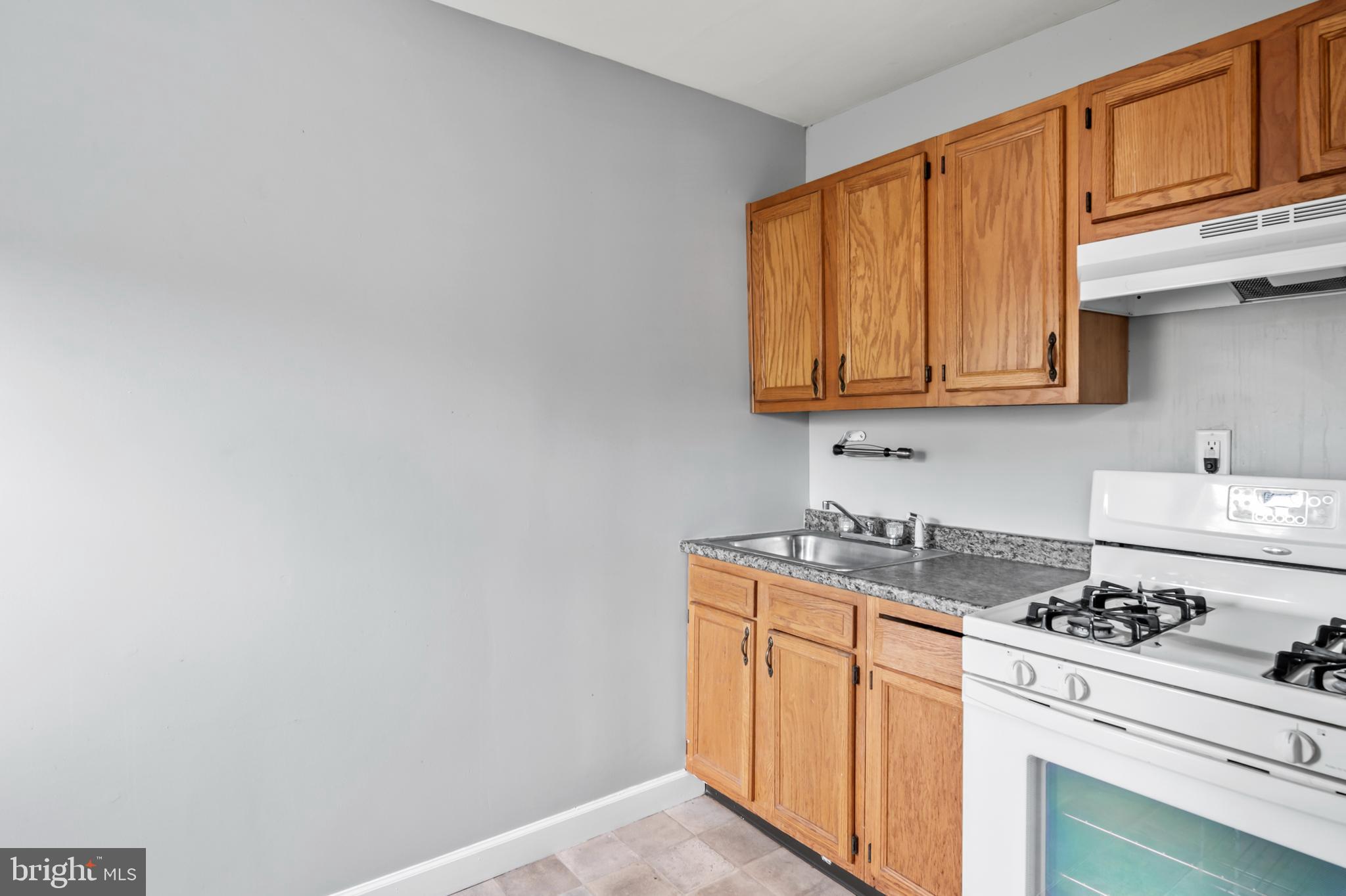1411 Filbert Street, Unit 2 Curtis Bay, MD 21226 - Photo 6 of 13 a kitchen with stainless steel appliances granite countertop a sink stove and cabinets