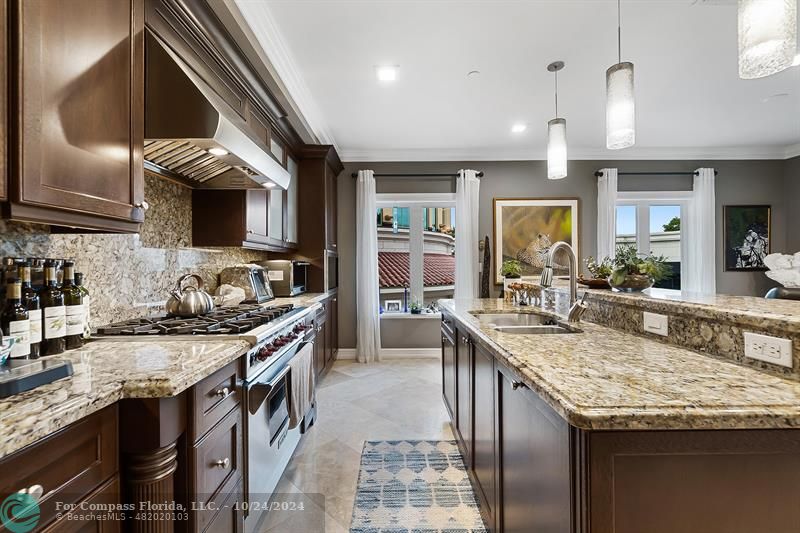 301 Tarpon Drive Fort Lauderdale, FL 33301 - Photo 4 of 21 a kitchen with granite countertop kitchen island stainless steel appliances a sink stove and cabinets
