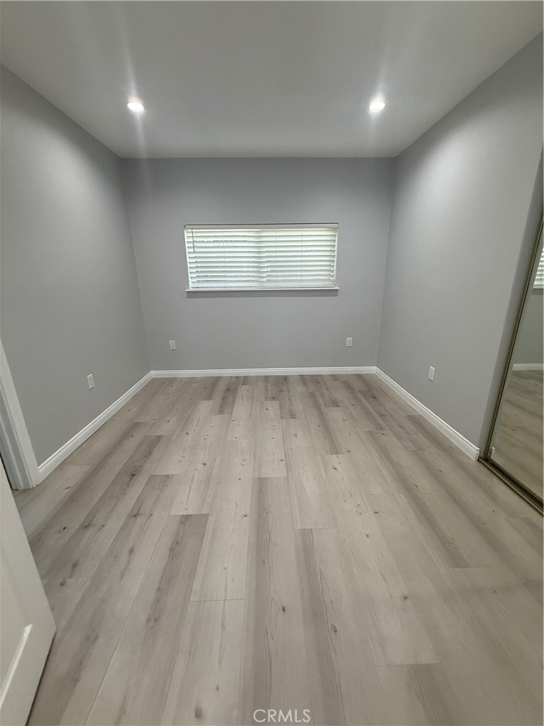 6504 Hesperia Avenue Reseda, CA 91335 - Photo 7 of 11 an empty room with wooden floor and windows