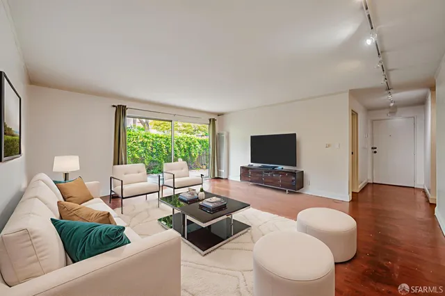 a living room with furniture flat screen tv and a large window