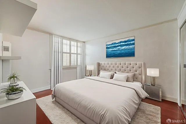 a bedroom with a bed and wooden floor