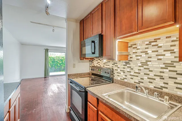 a kitchen with granite countertop a sink and a stove