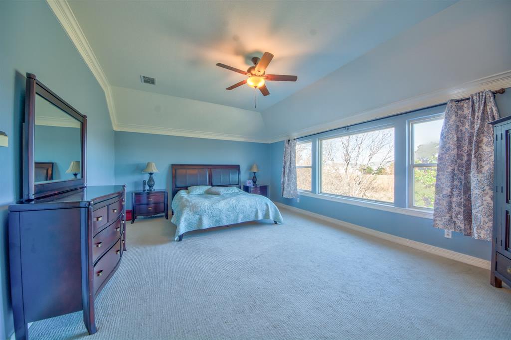 730 East Peninsula Drive Coppell, TX 75019 - Photo 14 of 34 a bedroom with a large bed and a chandelier fan