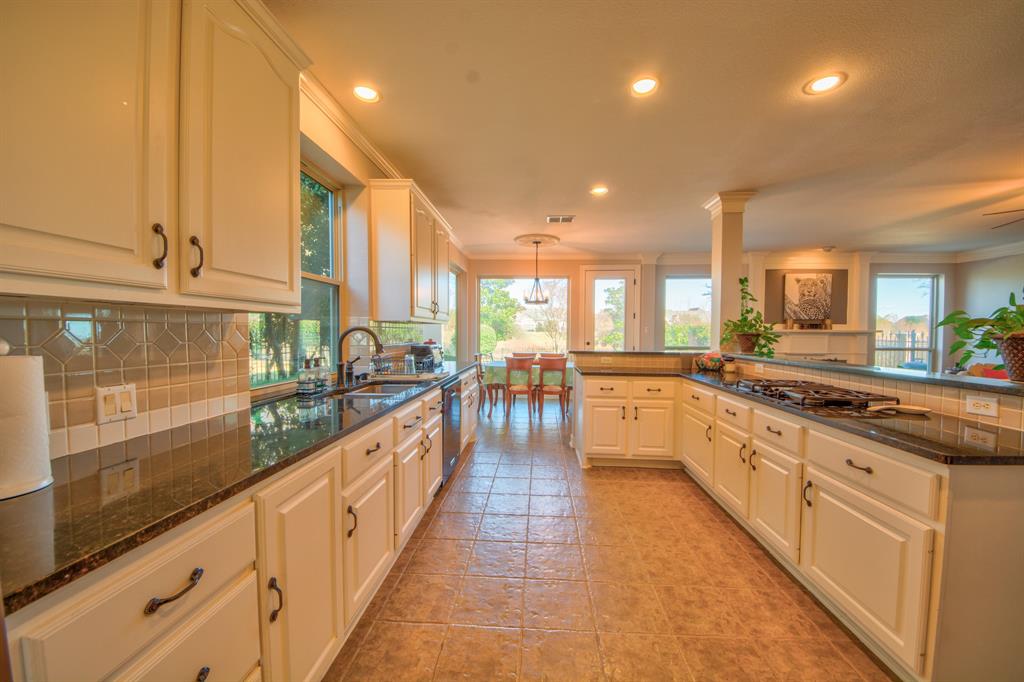 730 East Peninsula Drive Coppell, TX 75019 - Photo 8 of 34 a large kitchen with granite countertop a large counter top a sink stainless steel appliances and cabinets