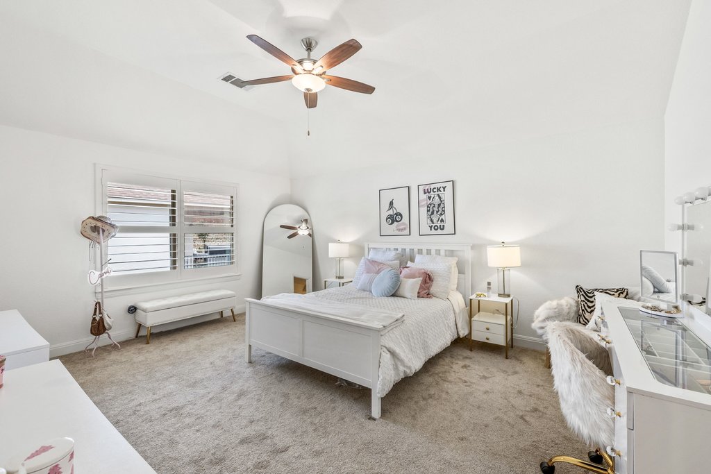 5812 Davenport Divide Road Austin, TX 78738 - Photo 26 of 40 Soft carpet underfoot, vaulted ceiling overhead, and a bright, neutral palette that feels fresh and welcoming. Plenty of wall space for art, a cozy reading chair, and natural light from shuttered windows.