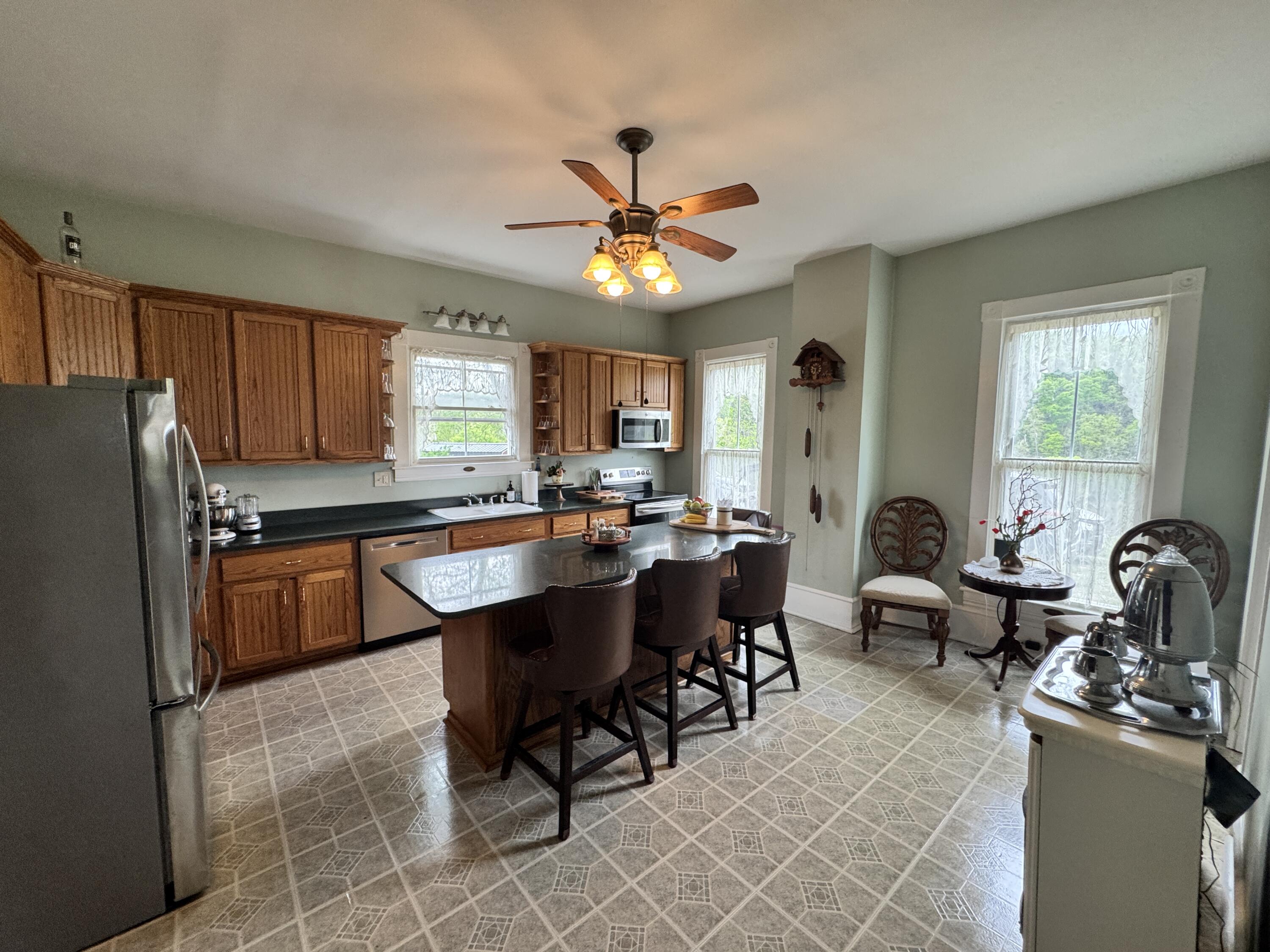 17749 Main Street Buchanan, VA 24066 - Photo 6 of 58 a kitchen with stainless steel appliances granite countertop a stove a sink dishwasher a dining table and chairs with wooden floor