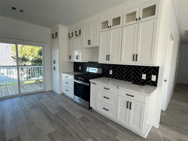 a kitchen with stainless steel appliances granite countertop a stove and a wooden cabinets