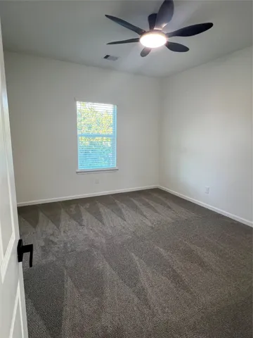 an empty room with a ceiling fan and a window