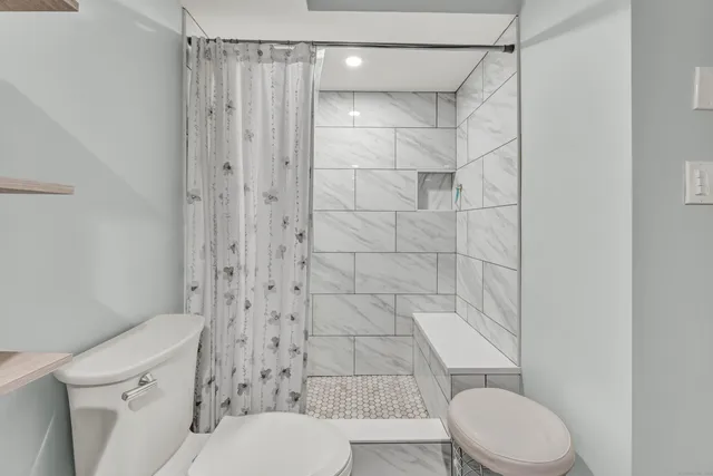 a white toilet sitting next to a bathroom sink