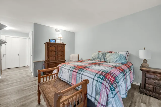 a bedroom with a bed and wooden floor
