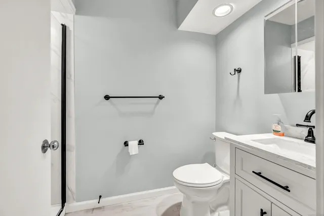 a bathroom with a sink toilet and a mirror