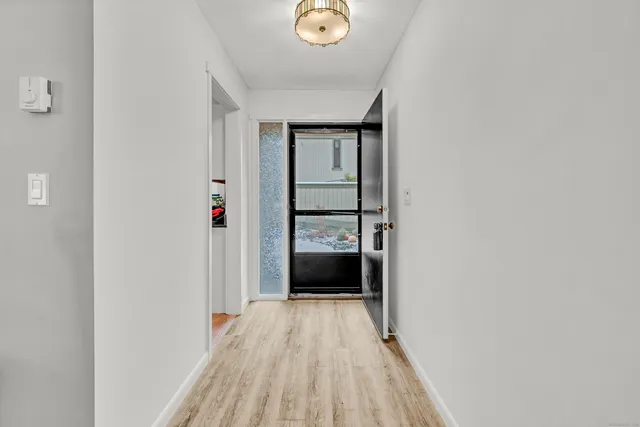 a view of a hallway with wooden floor and closet