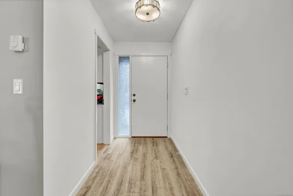 a view of a hallway with wooden floor and closet