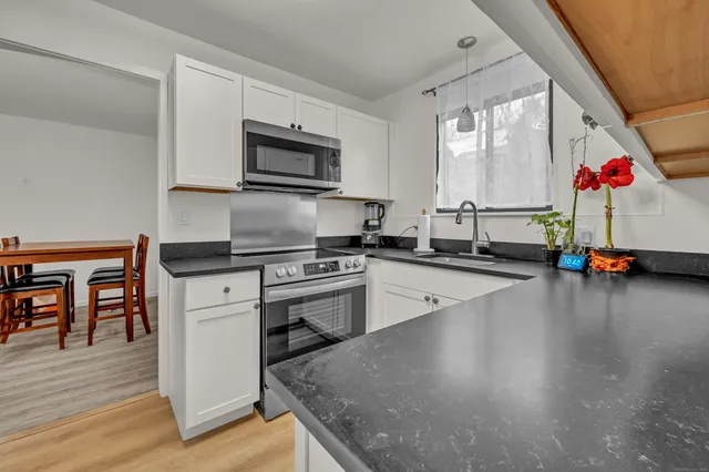 a kitchen with kitchen island granite countertop a stove and a microwave