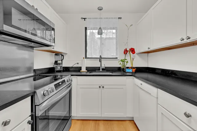 a kitchen with stainless steel appliances granite countertop a sink stove and cabinets